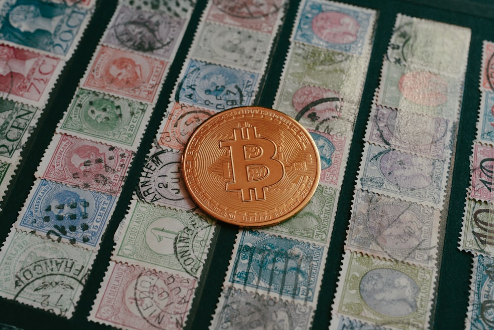 a bit coin sitting on top of a pile of stamps