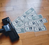 a pile of money sitting on top of a wooden floor