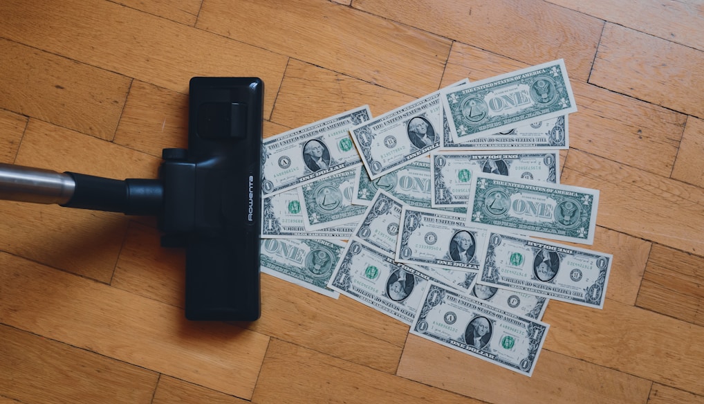 a pile of money sitting on top of a wooden floor