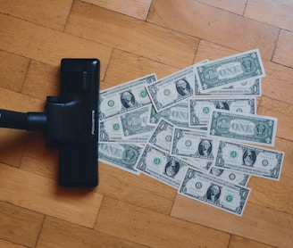 a pile of money sitting on top of a wooden floor