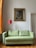 A cozy living room featuring a vibrant landscape painting above a comfortable sofa.