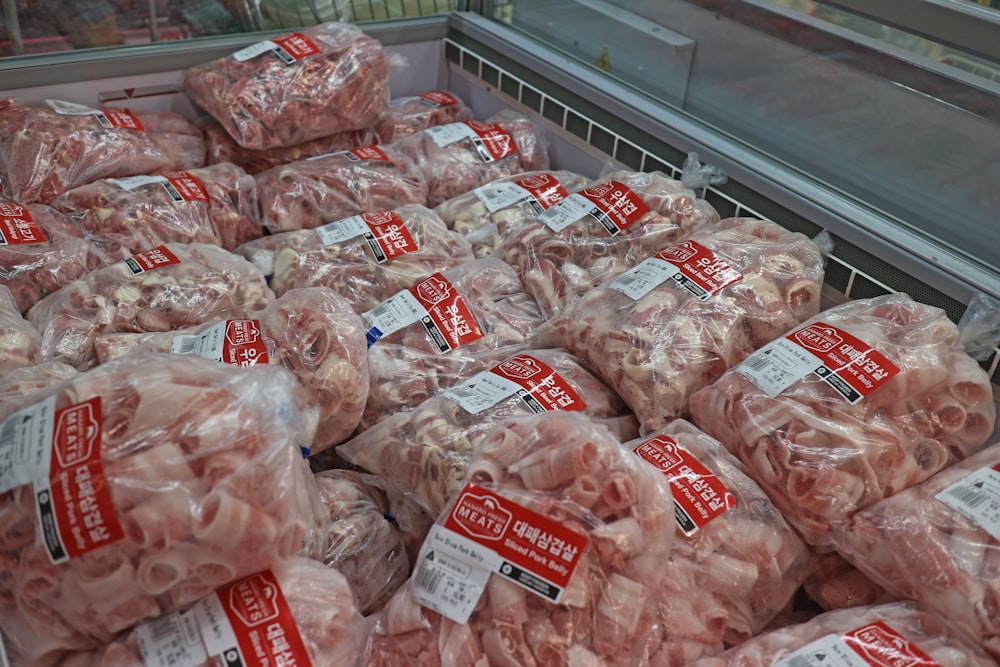 a pile of meat wrapped in plastic in a grocery store