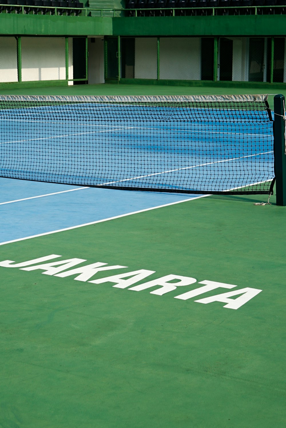 a tennis court with a net and a building in the background