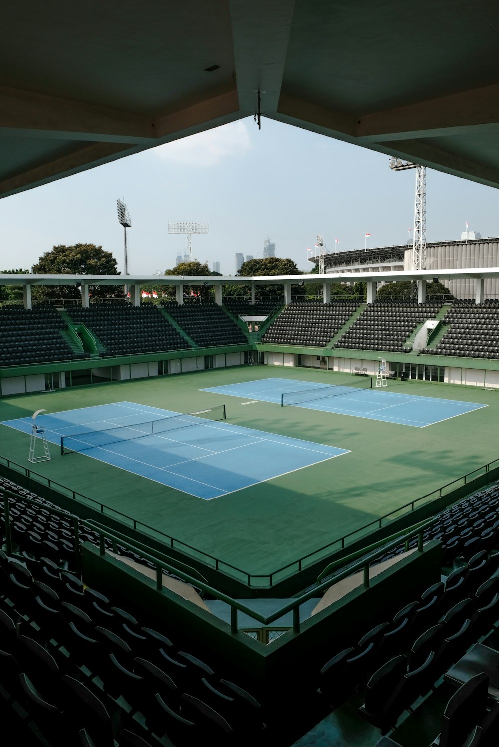 an empty tennis court with a view of the stands