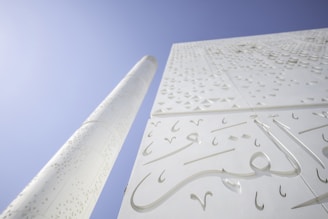 a close up of a tall white building with arabic writing on it