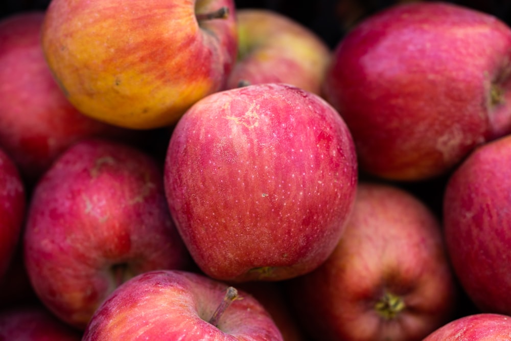 a pile of red apples sitting next to each other