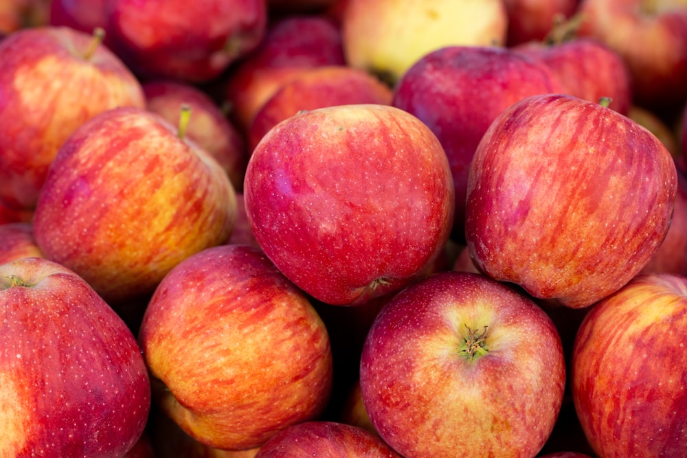 a pile of red apples sitting on top of each other