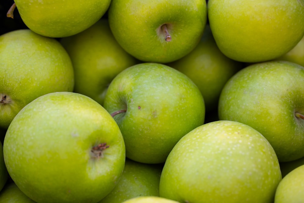 a pile of green apples sitting next to each other