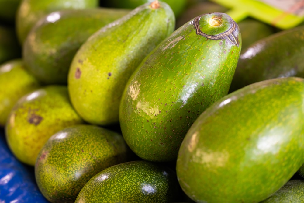 a pile of green avocados sitting on top of each other