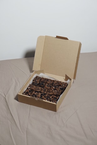 an open box of food sitting on a bed