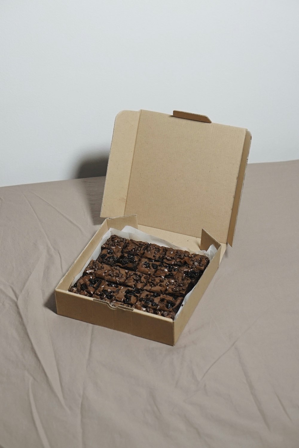 an open box of food sitting on a bed
