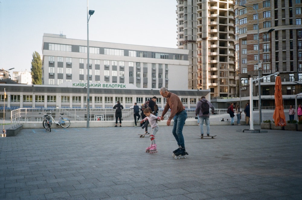 a man riding a skateboard with a little girl on it