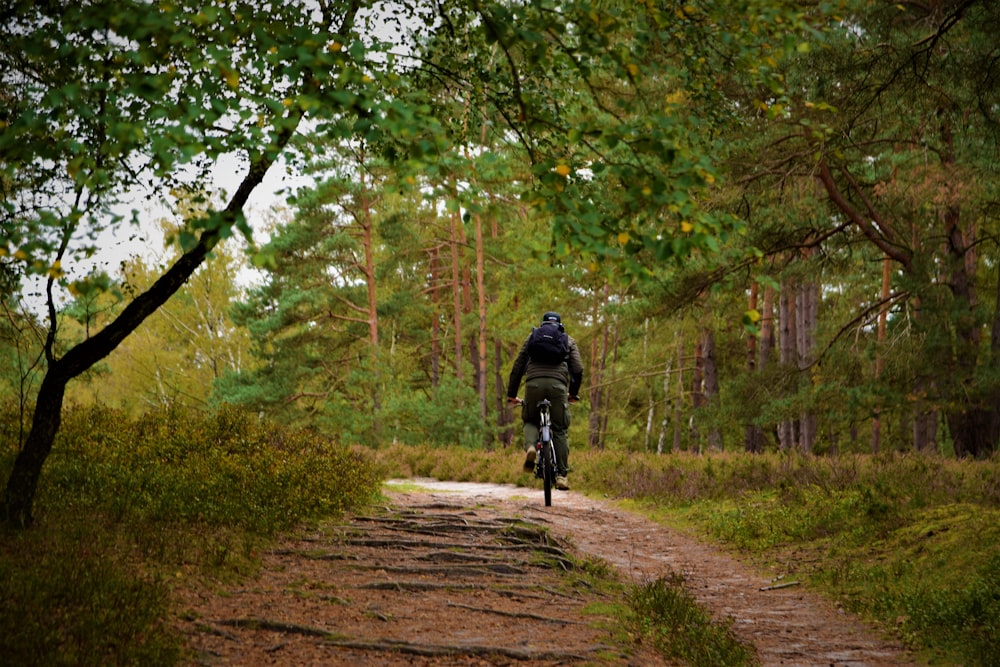 a man riding a bike down a dirt road