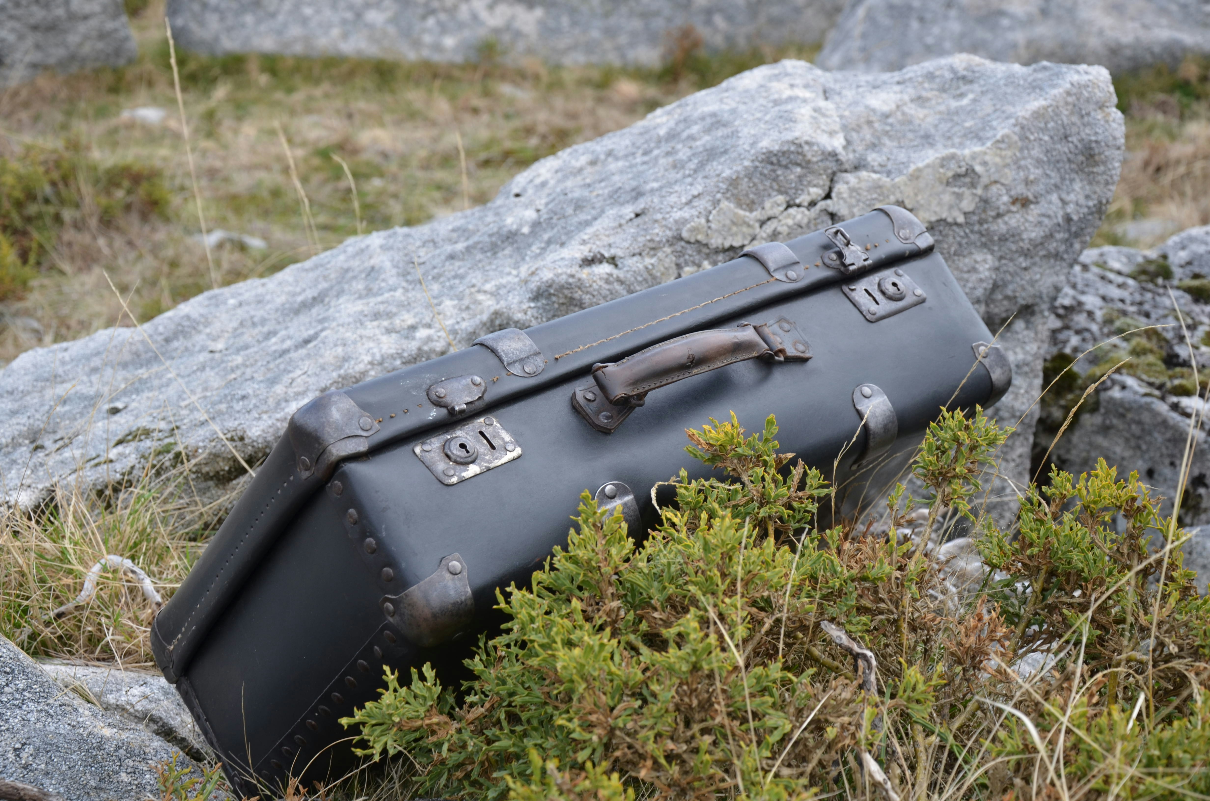 a piece of luggage sitting on top of a pile of rocks