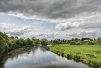 The serene flow of one of Punjab’s five rivers winding through lush green fields.