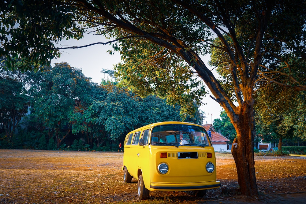 a yellow van parked next to a tree