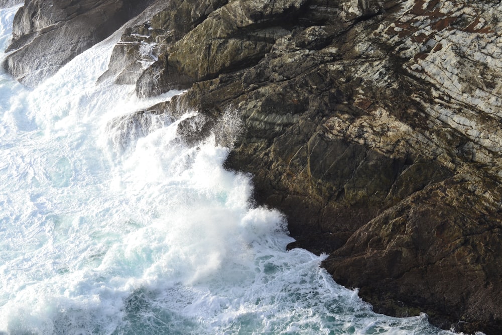 a large body of water next to a rocky cliff