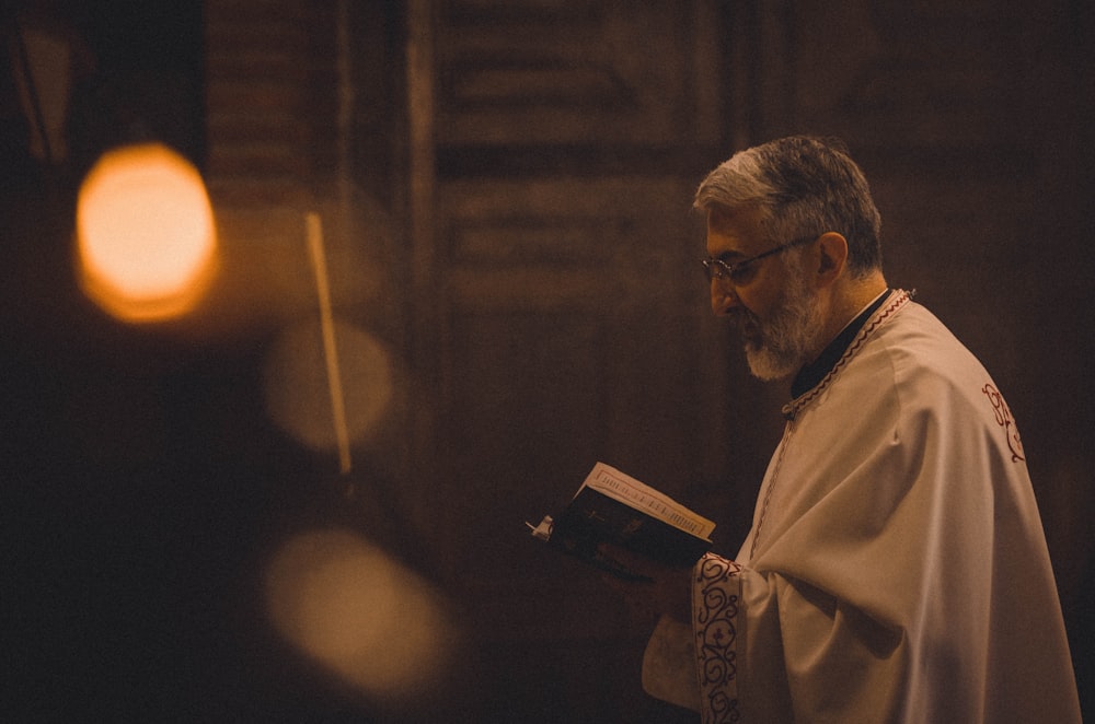 a man in a white robe holding a book