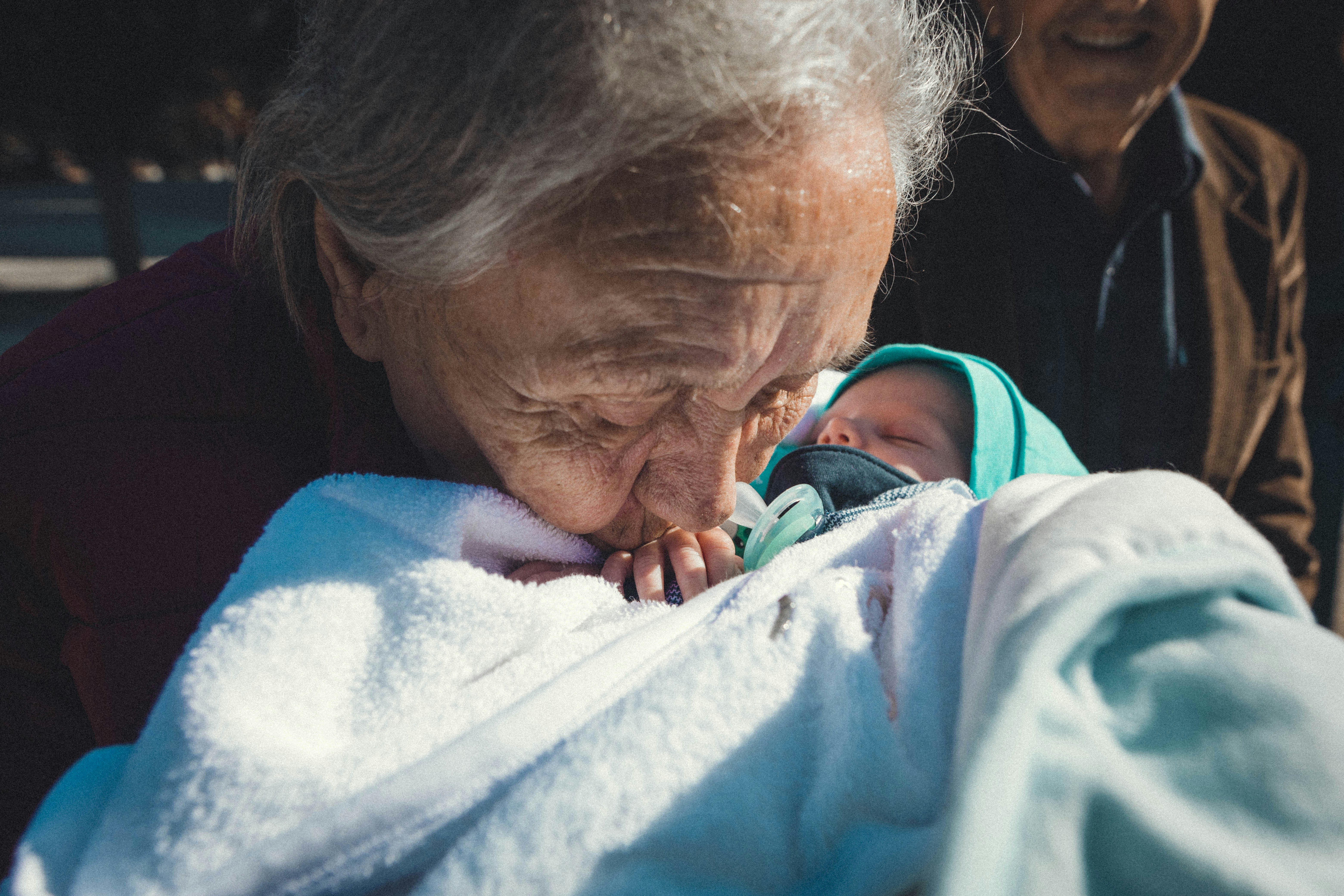 a woman holding a baby wrapped in a blanket