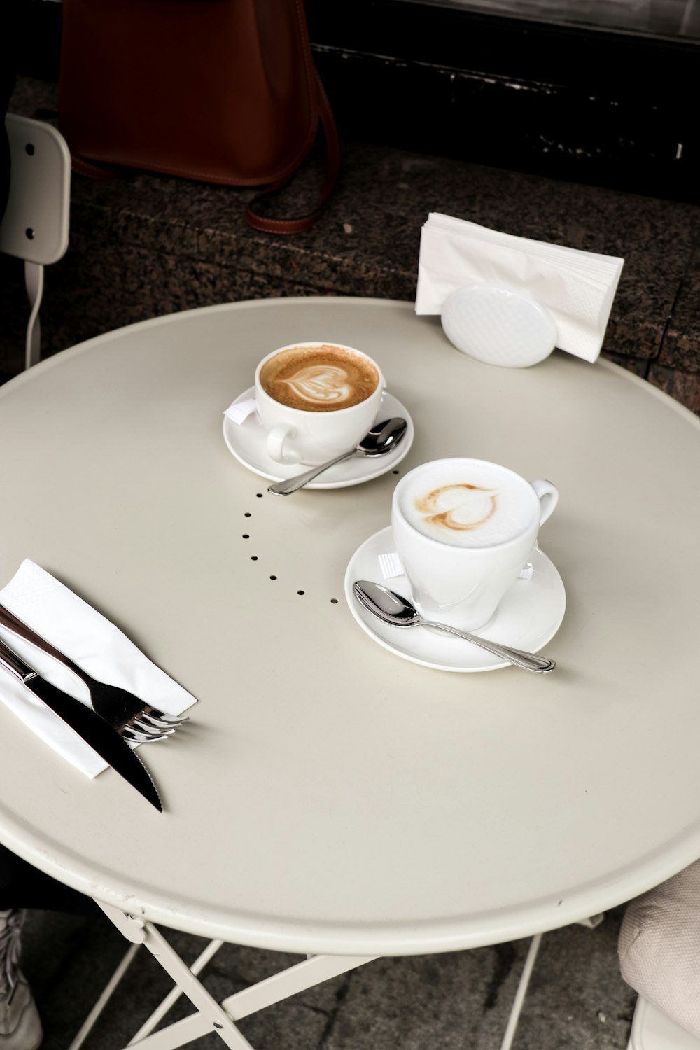 a couple of cups of coffee sitting on top of a white table