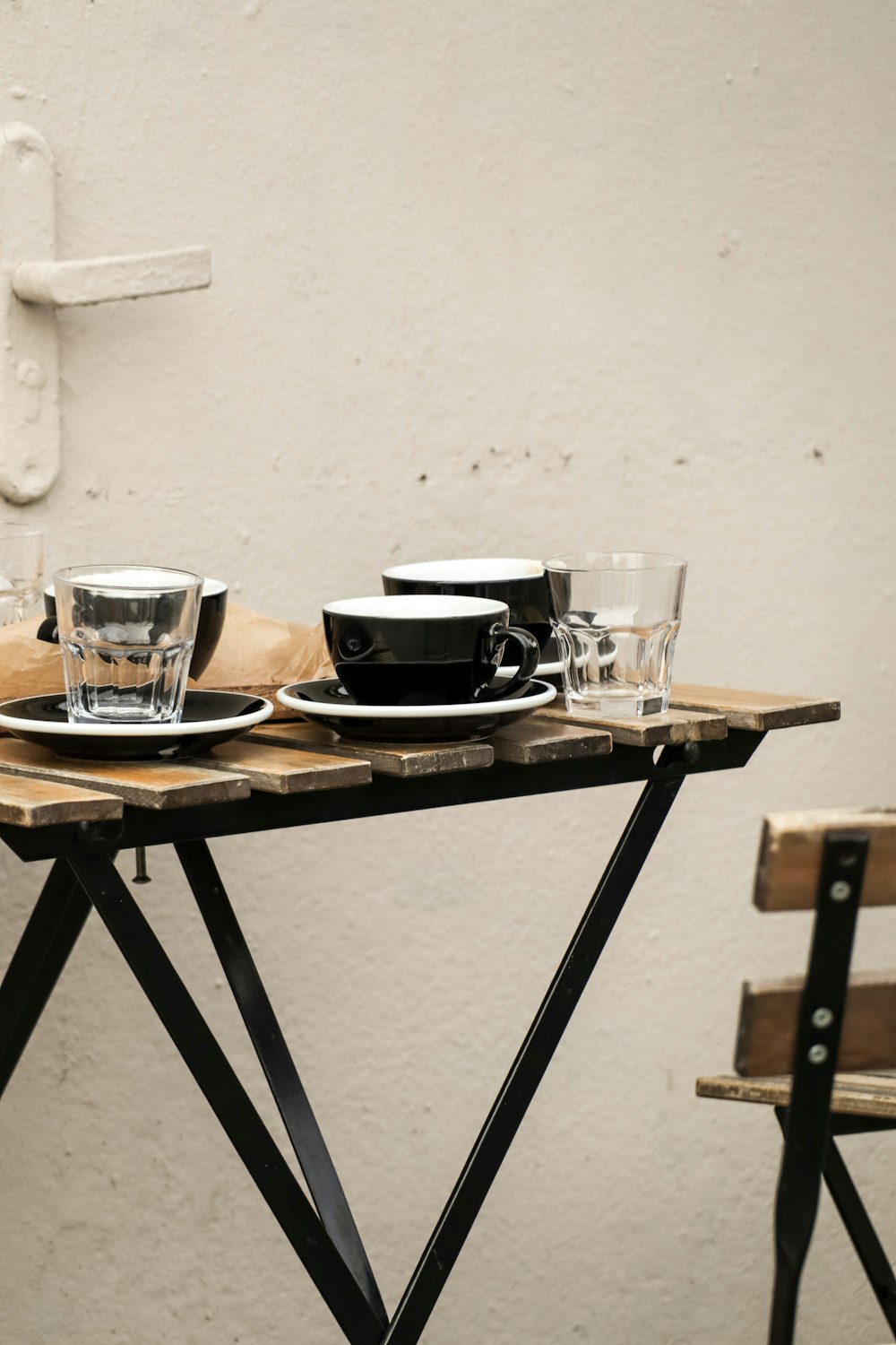 a wooden table topped with plates and cups