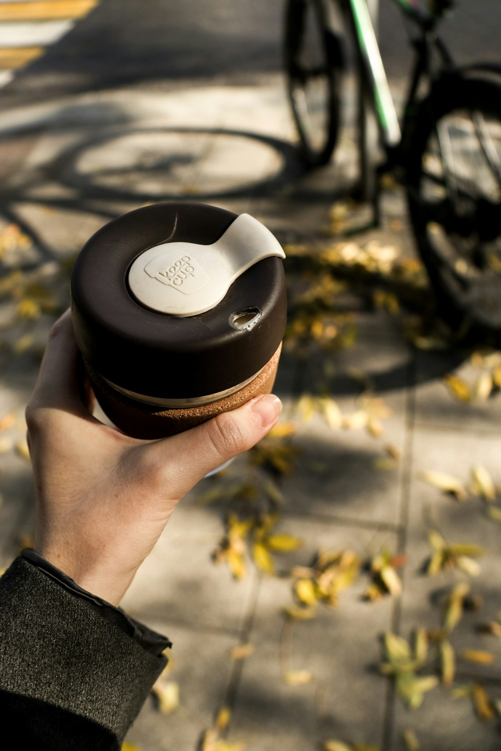 a person holding a donut in front of a bike