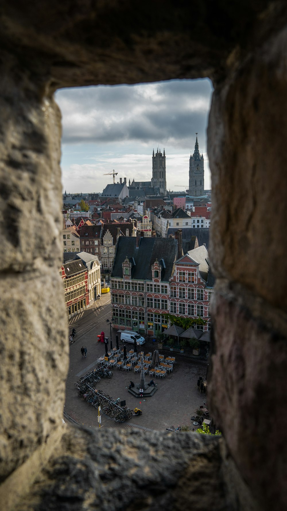 a view of a city through a hole in a stone wall