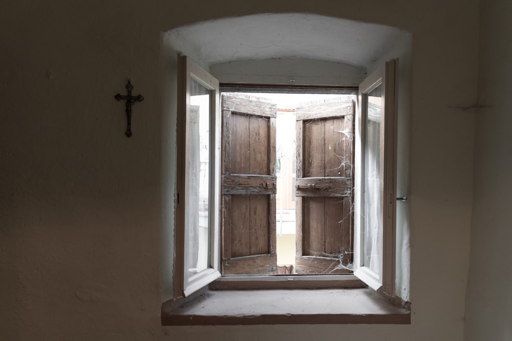 a window with a cross on the side of it