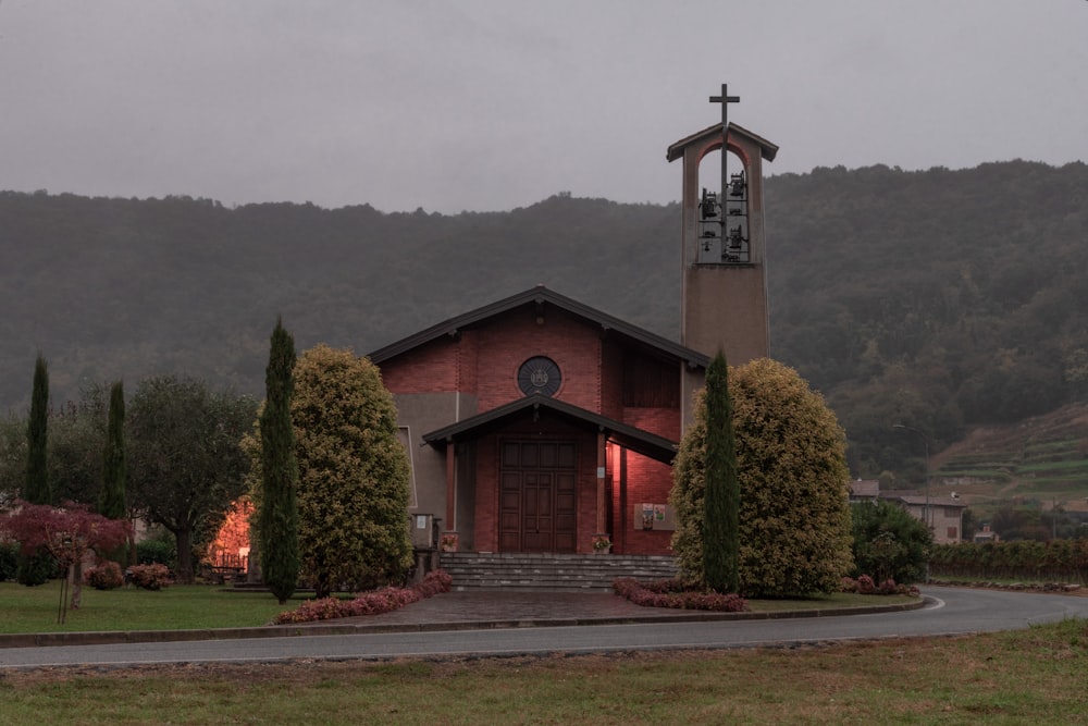 a church with a steeple surrounded by trees and bushes