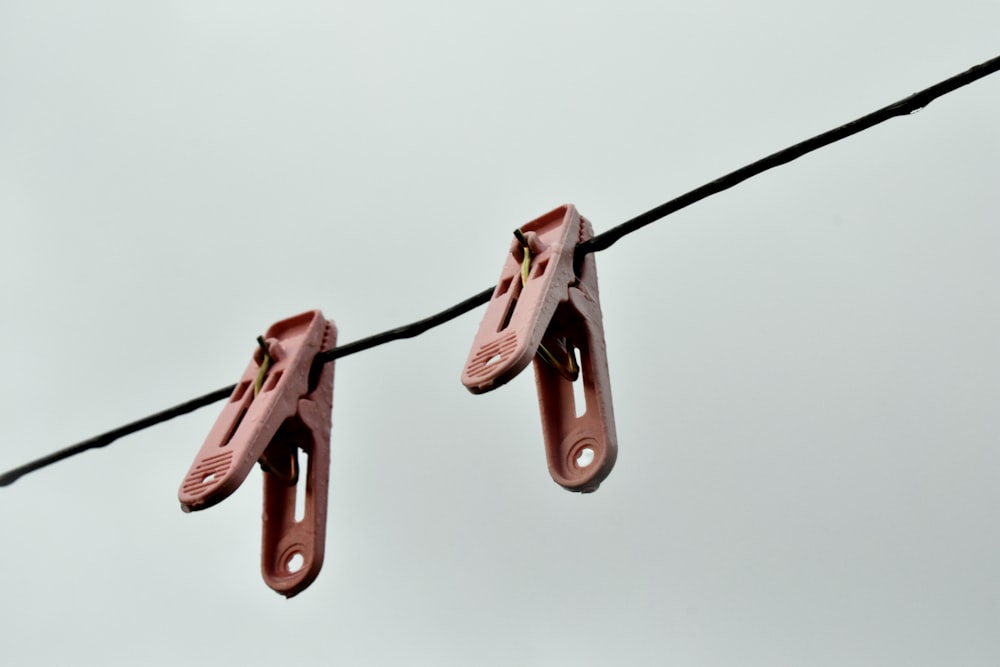 a pair of pink shoes hanging from a wire