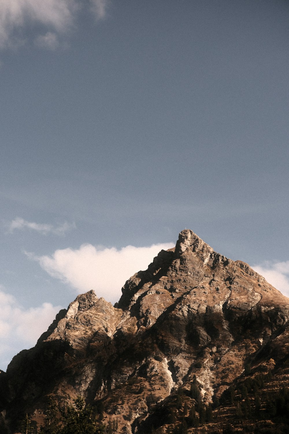 a very tall mountain with some clouds in the sky