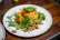 a white plate topped with pasta and greens