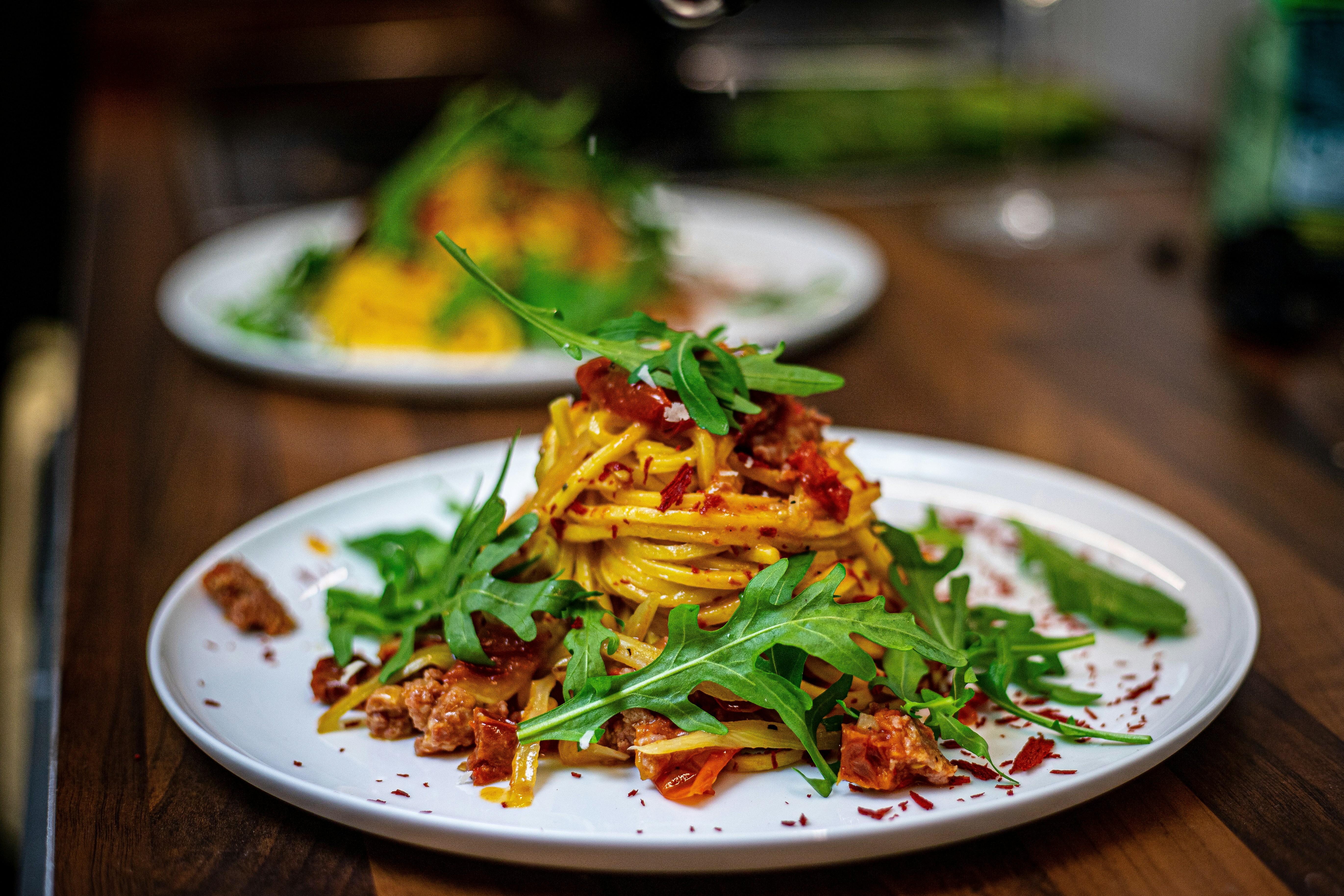 a white plate topped with pasta and greens