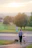 A young family walking their dog near the sandy beach area of River Park.