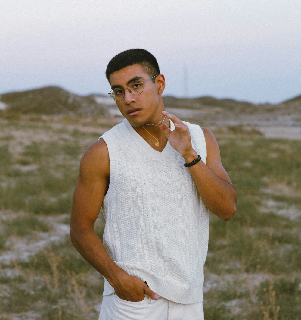 a man standing in a field with his hand on his chin