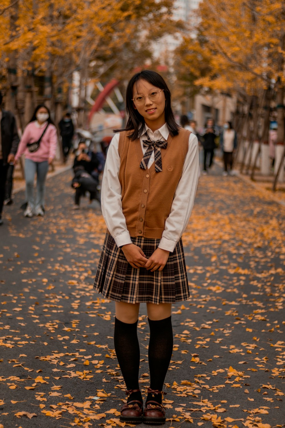 a woman in a school uniform standing in the middle of a street