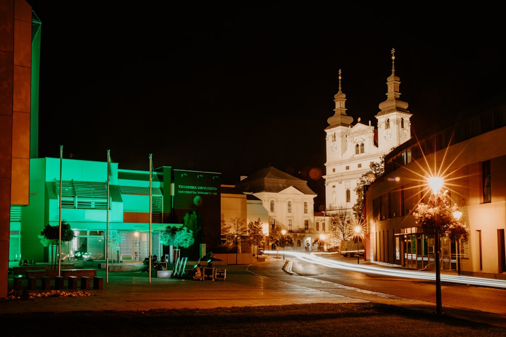 a city street at night with a church in the background