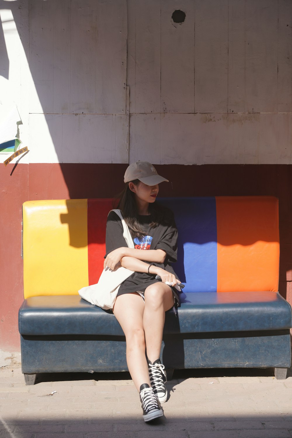 a woman sitting on a bench in front of a building