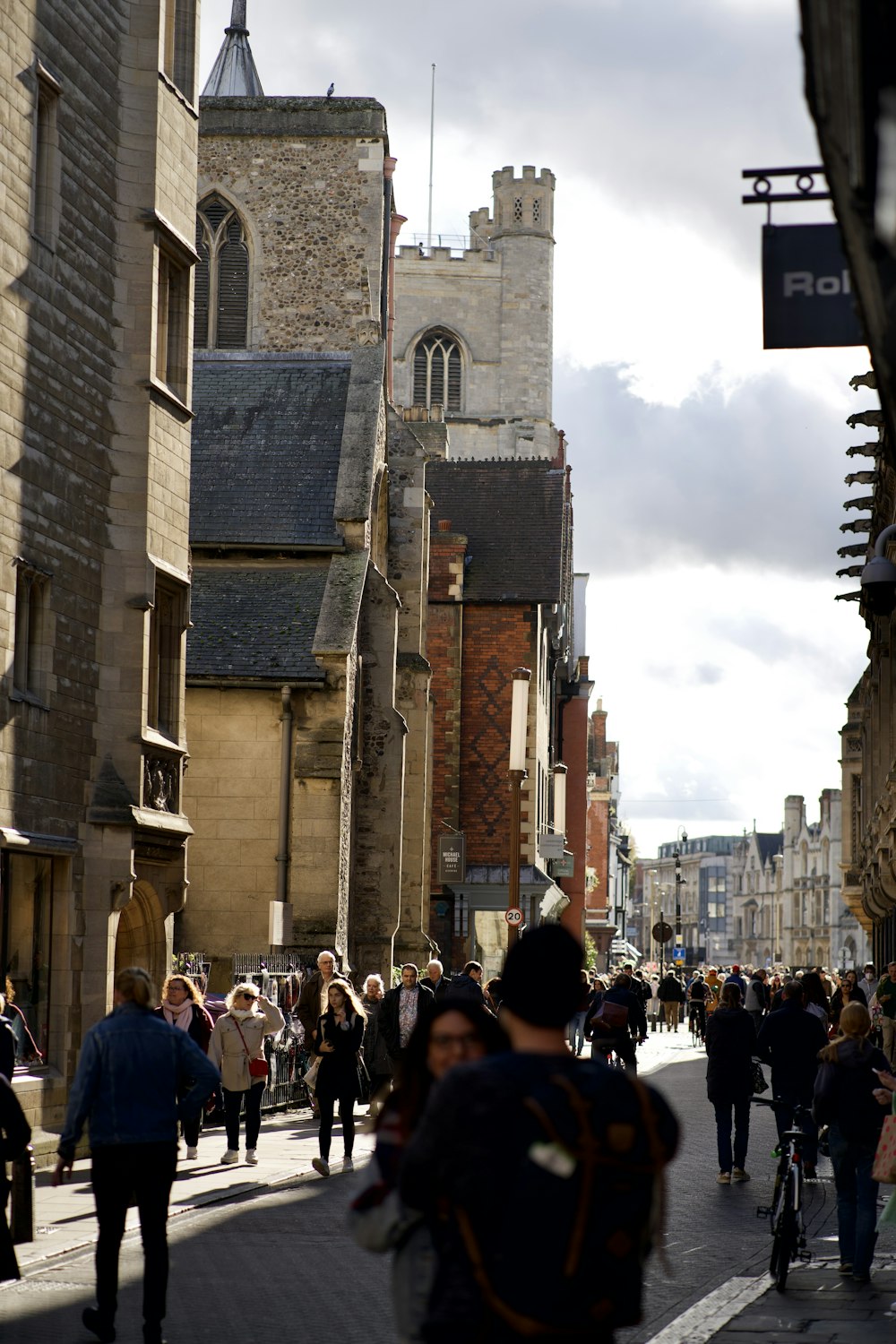 a group of people walking down a street next to tall buildings