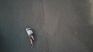 a man laying on the ground in the middle of the road