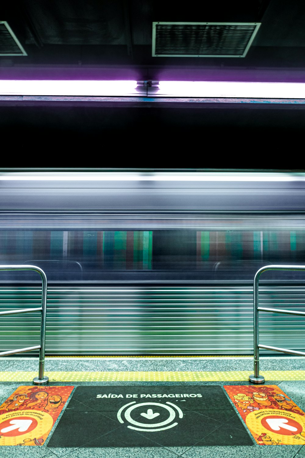 a train passing by a platform with a sign on it