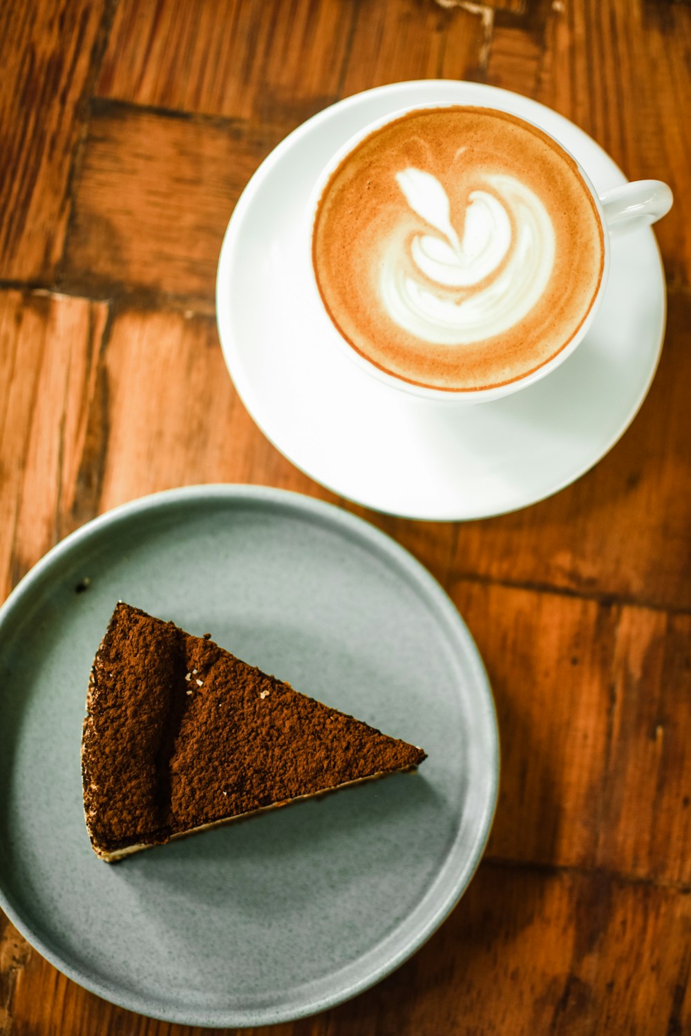 a piece of cake on a plate next to a cup of coffee