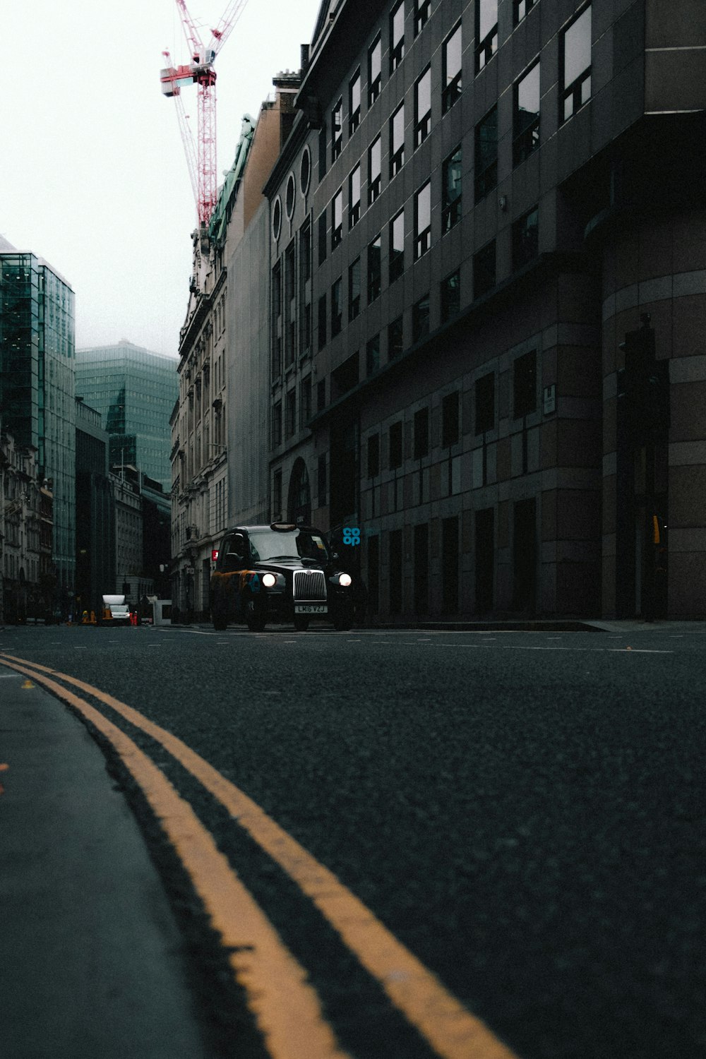 a truck driving down a street next to tall buildings