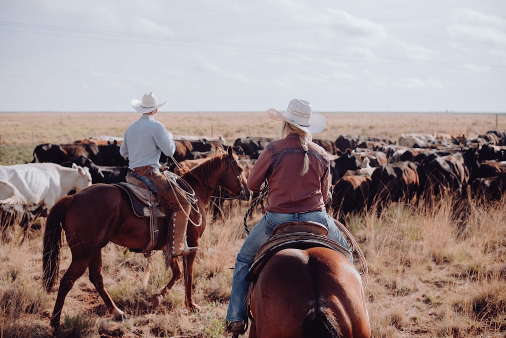 Un par de personas montando a lomos de caballos