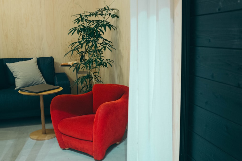 a red chair sitting in a living room next to a table