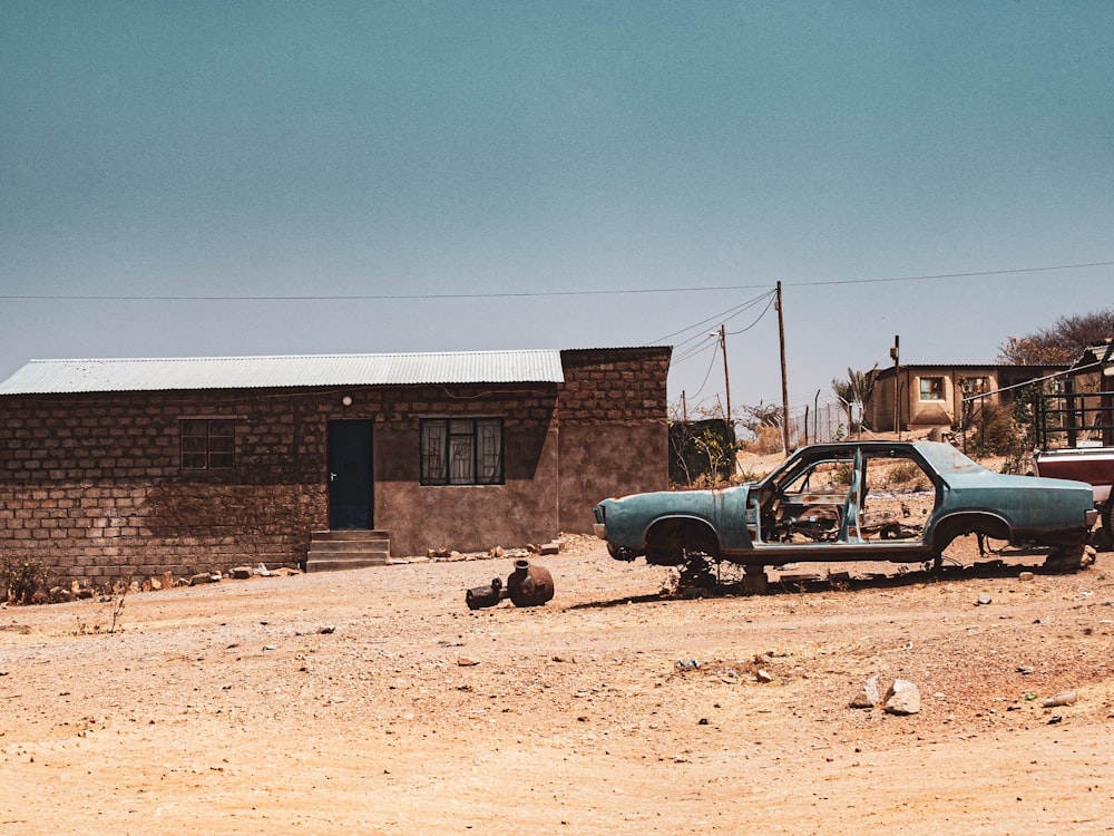 a blue car parked in front of a brick building