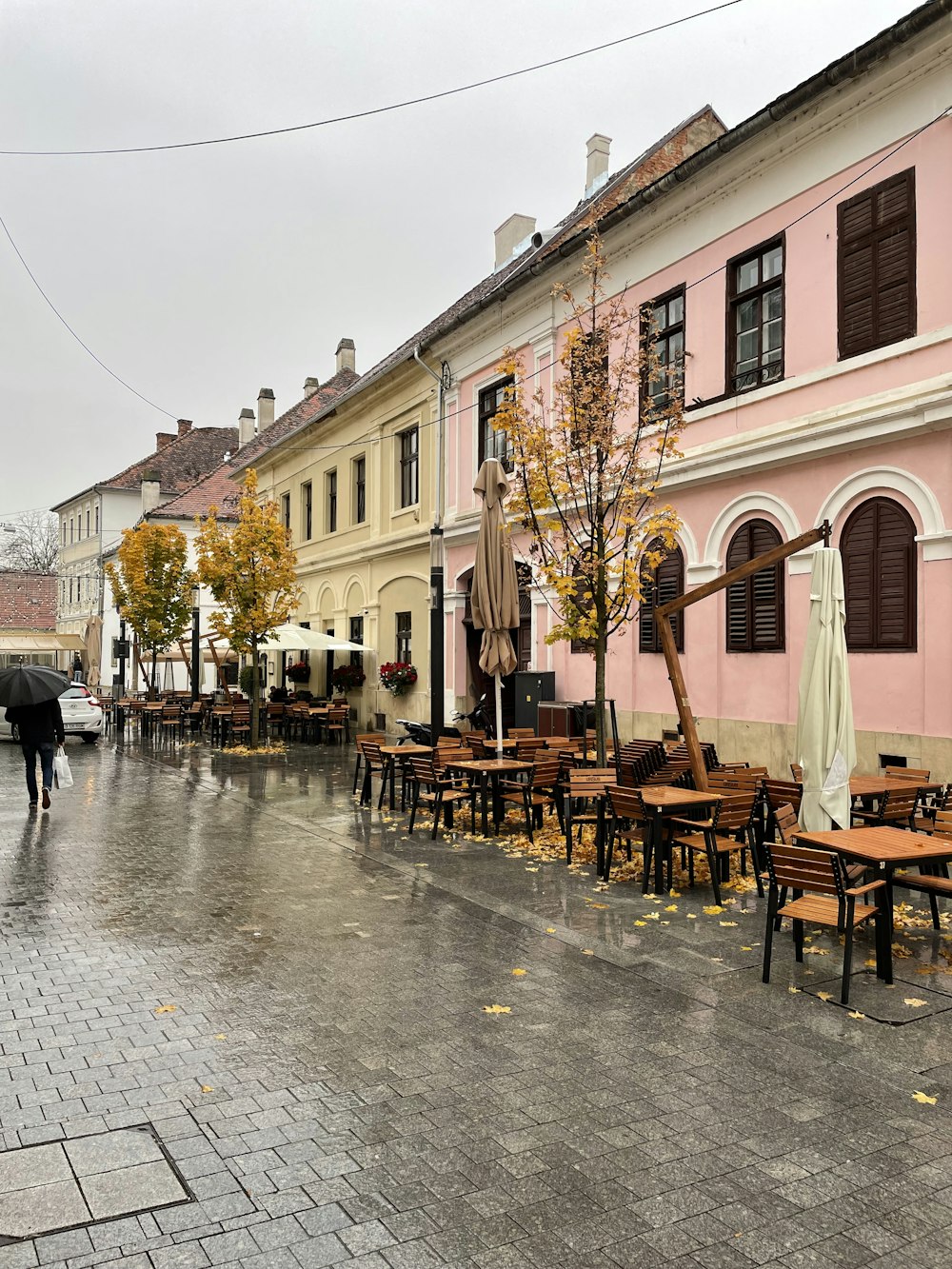 a row of tables and chairs in front of a pink building