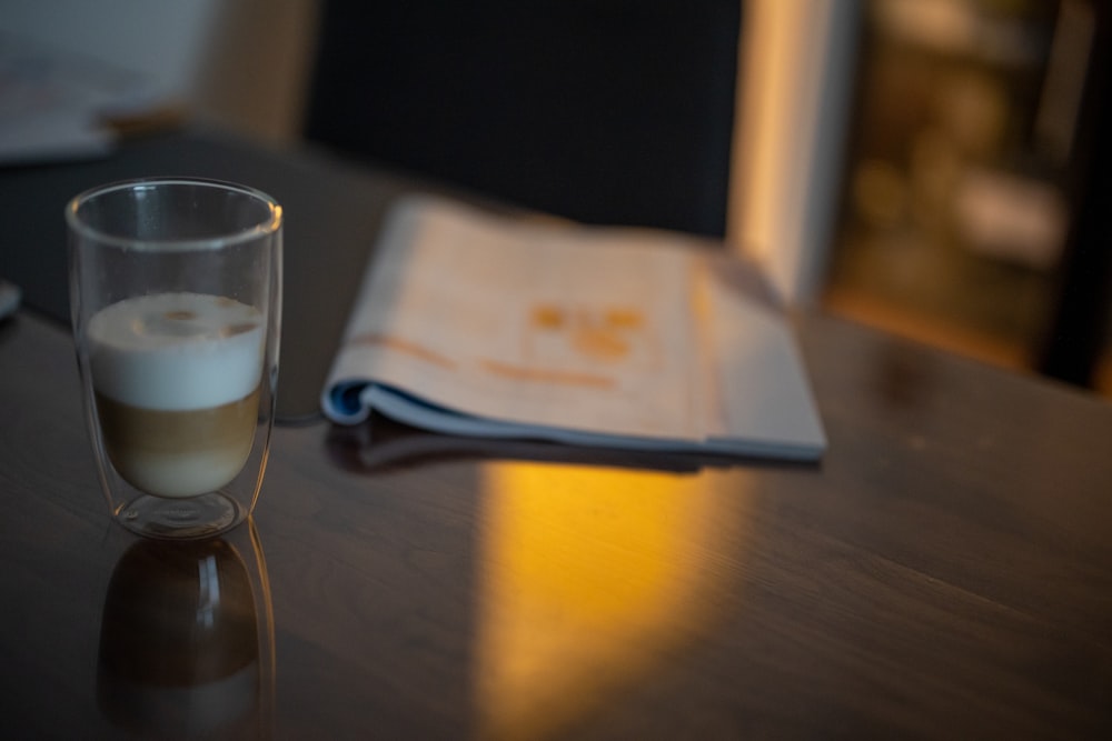 a glass of liquid sitting on top of a wooden table