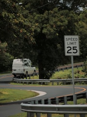 A delivery van speeding along a highway surrounded by green fields.