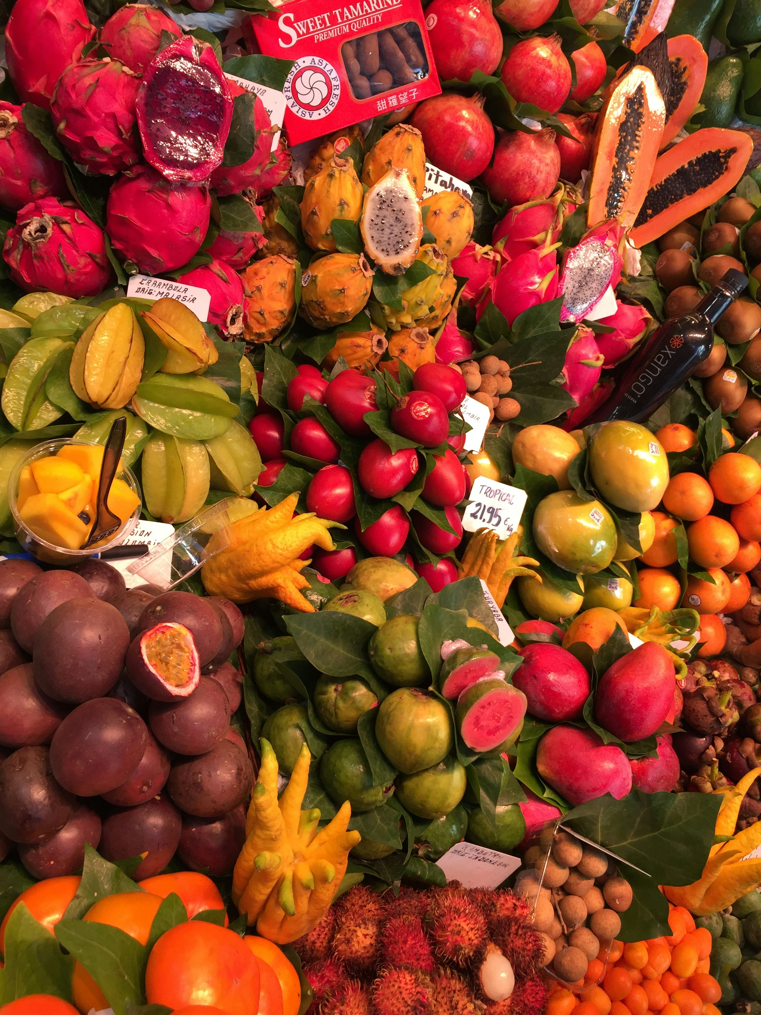Colorful assortment of tropical fruits including mango dragon fruit and passion fruit in warm golden light